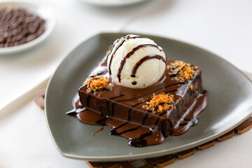 Molten chocolate cake served cold with a scoop of vanilla ice cream, rich Western dessert.