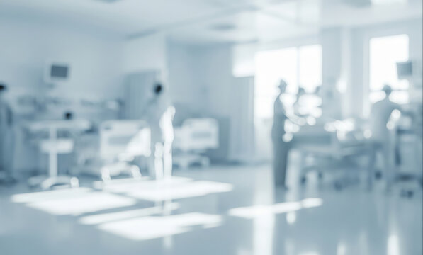 Blurred hospital room with medical equipment and personnel in a bright setting.