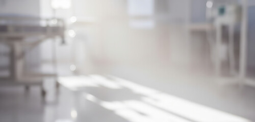 Blurred hospital interior with a hospital bed and medical equipment.