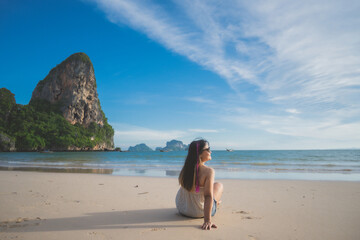 happy woman sit down on the beach at krabi province, Thailand. soft focus
