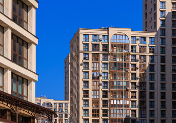 City view on a sunny day. Modern building and houses against the blue sky.