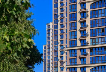 City view on a sunny day. Modern building and houses against the blue sky.