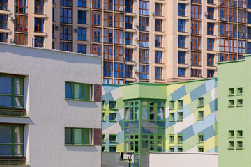 City view on a sunny day. Modern building and houses against the blue sky.
