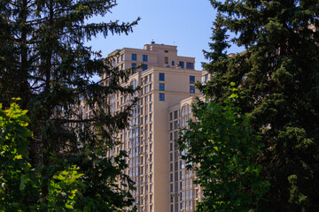 Cityscape on a summer day, modern buildings and houses against the blue sky 