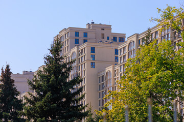 City view on a sunny day. Modern building and houses against the blue sky.