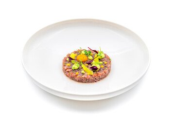 Meat tartare with quail eggs on a white porcelain plate