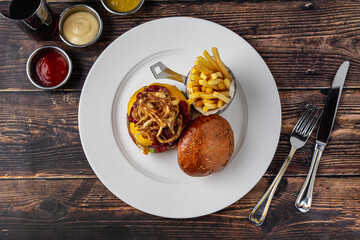 Gourmet beef burger with pastrami, cheddar, caramelized onions, and fries