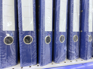 Blue folders on a shelf in a store, close-up photo