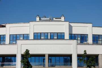 Cityscape on a summer day, modern buildings and houses against the blue sky 