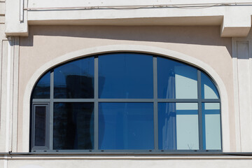 Fototapeta premium City view on a sunny day. Modern building and houses against the blue sky.