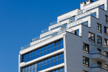 City view on a sunny day. Modern building and houses against the blue sky.
