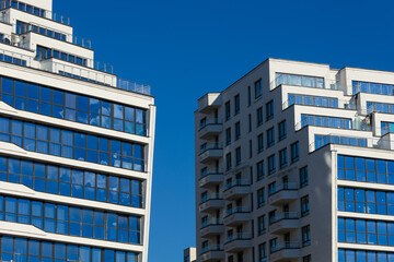 City view on a sunny day. Modern building and houses against the blue sky.