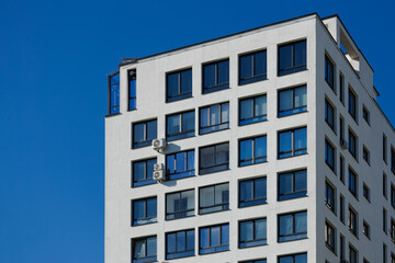 City view on a sunny day. Modern building and houses against the blue sky.
