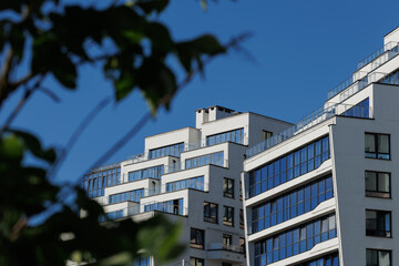 City view on a sunny day. Modern building and houses against the blue sky.