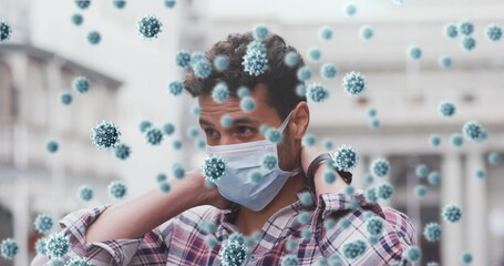 Standing man adjusting face mask and wristband on empty street, with 3D virus particles floating