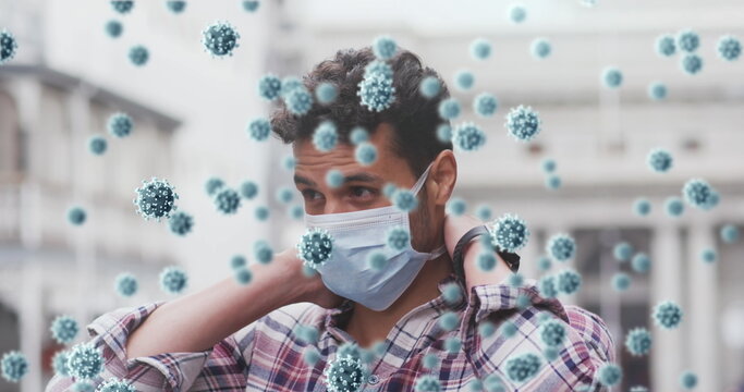 Standing man adjusting face mask and wristband on empty street, with 3D virus particles floating - Powered by Adobe