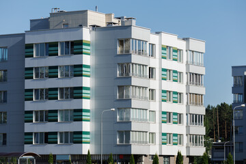 City view on a sunny day. Modern building and houses against the blue sky.