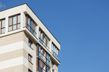 City view on a sunny day. Modern building and houses against the blue sky.