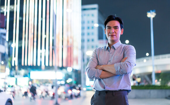 Young man poses confidently in vibrant Hanoi at night, showcasing the dynamic urban landscape - Powered by Adobe
