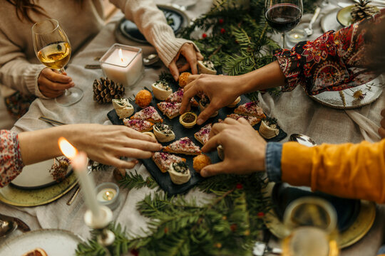 Friends sharing christmas appetizers at festive dinner table