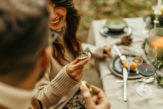 Couple enjoying gourmet appetizers and wine at outdoor autumn dinner party