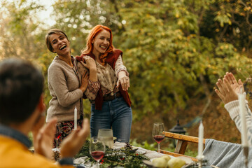 Woman showing engagement ring to friends celebrating outdoors