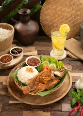 A river fish called Tilapia fishor in Indonesia called Nila fish that is cooked by frying and served with kremesan and also a delicious sambal.