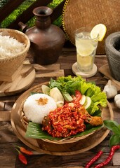 Ayam Geprek or Spicy Crispy Chicken Smashed or Ayam Geprek served with cucumbers, lettuce and rice.