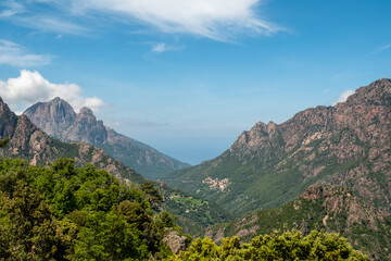 The village of Ota near the west coast of the island of Corsica with the towering peaks of Capu d'Ota and Capu d'Orto behind and the Mediterranean sea in the distance