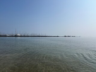 Obraz premium Calm sea view with marina and moored yachts on horizon