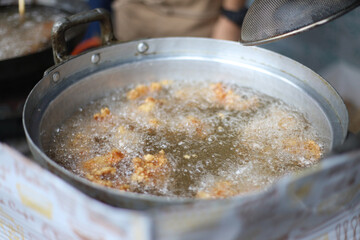 大鍋で鶏のから揚げを揚げる様子
