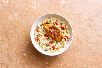 Orzo pasta with fried chicken breast, tomatoes and herbs. Italian food.