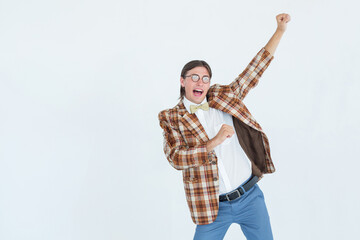 Man wearing plaid blazer and yellow bow tie celebrating with fist pump in studio, copy space