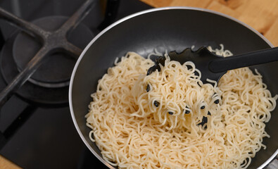 Noodles in a pan, making ramen