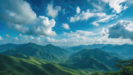Fototapeta premium A breathtaking view of lush green mountain landscape under a bright blue sky with scattered clouds, evoking tranquility and natural beauty.
