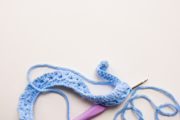 Blue crochet yarn with hook on white background