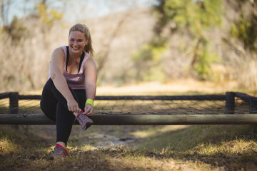 Fototapeta premium Neon-accented sneakers are being tied on rustic wooden and metal bench in sunny forest clearing