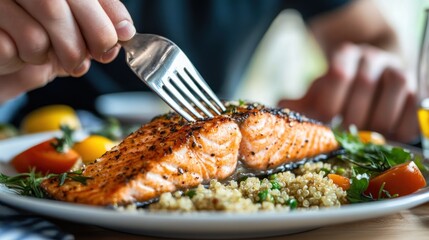 Closeup of a Person Forking Pan-Seared Salmon with Quinoa and Vegetables