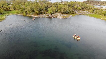 aerial view of two small boats fishing in a shallow bay with spinning rods in Aland islands