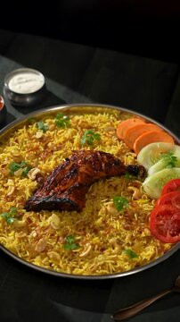 Chicken Mandi, in a big steel plate, arranged beautifully with some carrots, tomatoes, and cucumber slices