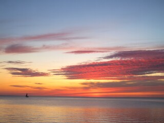 Fototapeta premium Serene sunset sailboat peaceful ocean horizon