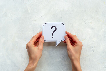 Hands are holding Question mark speech bubbles top view. FAQ concept
