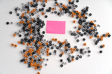 A piece of pink paper surrounded by a scattered assortment of letters and numbers, symbolizing...