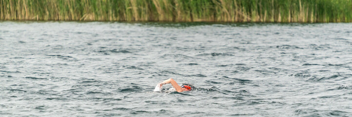 Ein Sportler schwimmt in einem See bei leichtem Wellengang