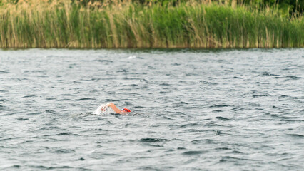 Ein Sportler schwimmt in einem See bei leichtem Wellengang
