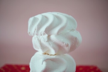 White marshmallows on a pink background.