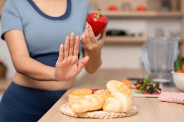 ESG and Healthy Choices. Woman rejecting unhealthy snacks in a modern kitchen.