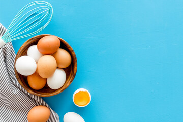 Bowl of chicken eggs on cooking table, top view. Food pattern. Easter background