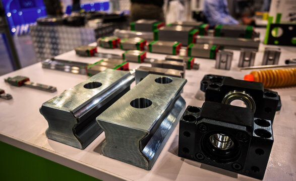 Assortment of precision industrial mechanical components on display, featuring linear guides and bearings on a table.