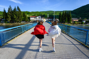 Girls running on Kulen Vakuf bridge in Bosnia. Family visiting a famous bridge over the Una river to enter the small town of Kulen Vakuf in Bosnia.